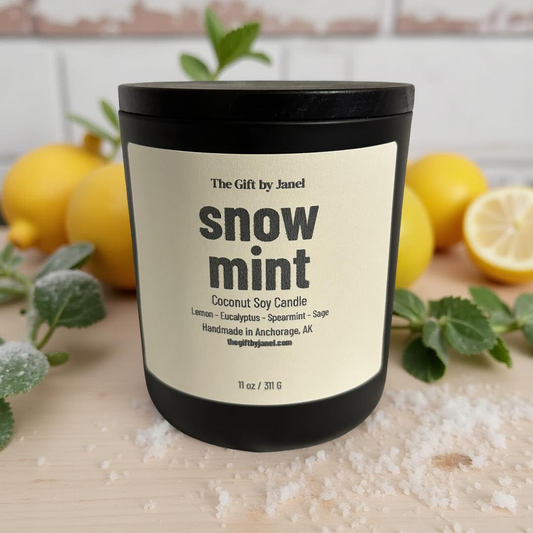 Coconut soy candle labeled 'snow mint' with lemons and greenery in the background
