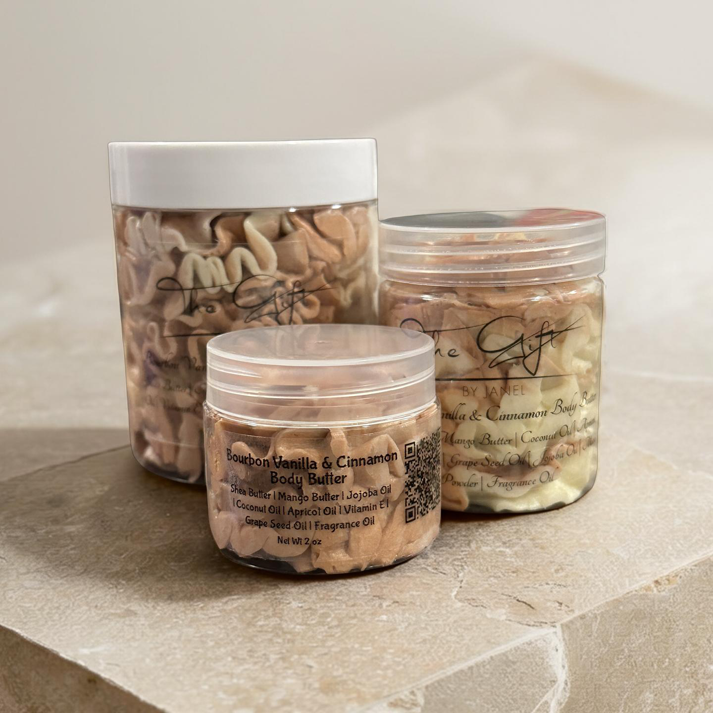 Three jars of body butter on a stone surface