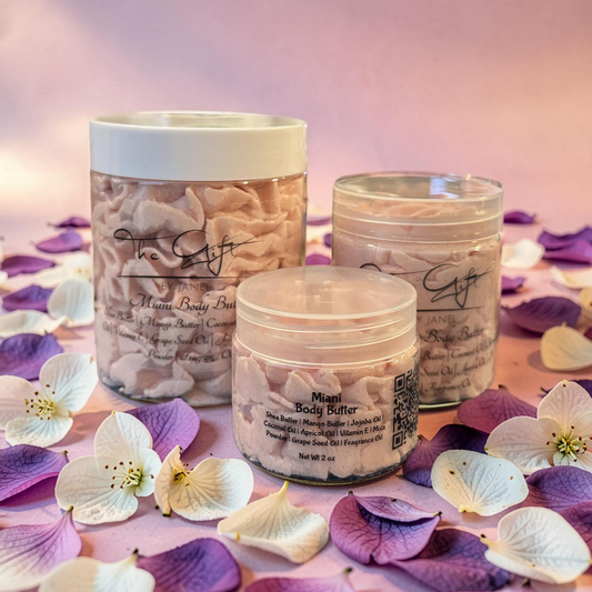 Three jars of body butter on a surface with purple and white flowers.