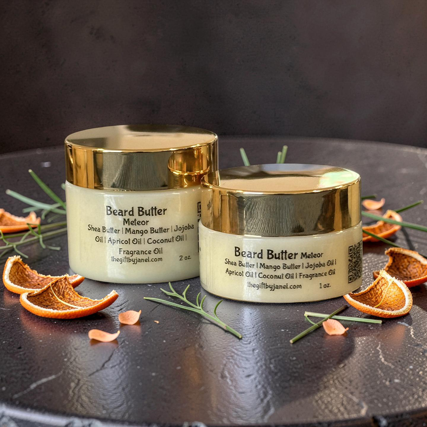 Two jars of Beard Butter Meteor on a dark surface with orange slices and green leaves.
