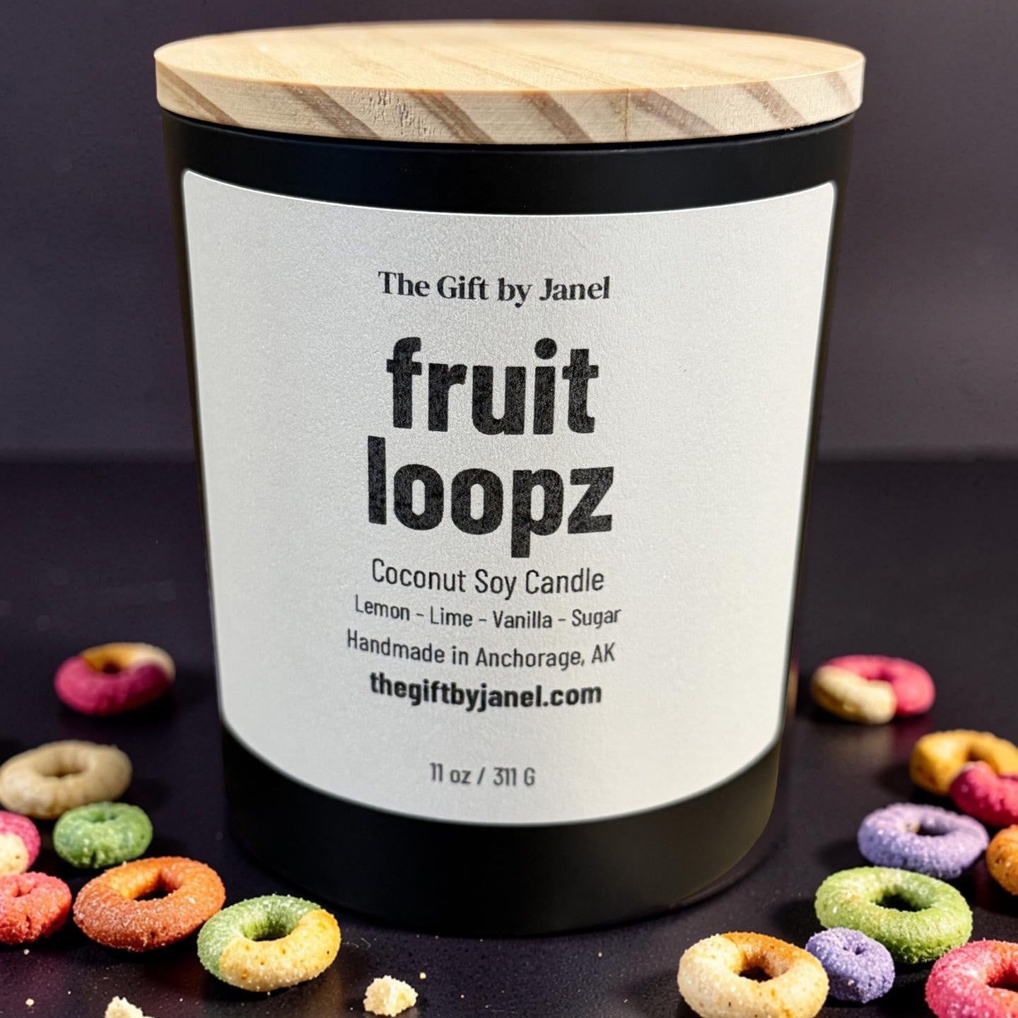 Candle labeled 'fruit loopz' with colorful donut-shaped candies on a dark background