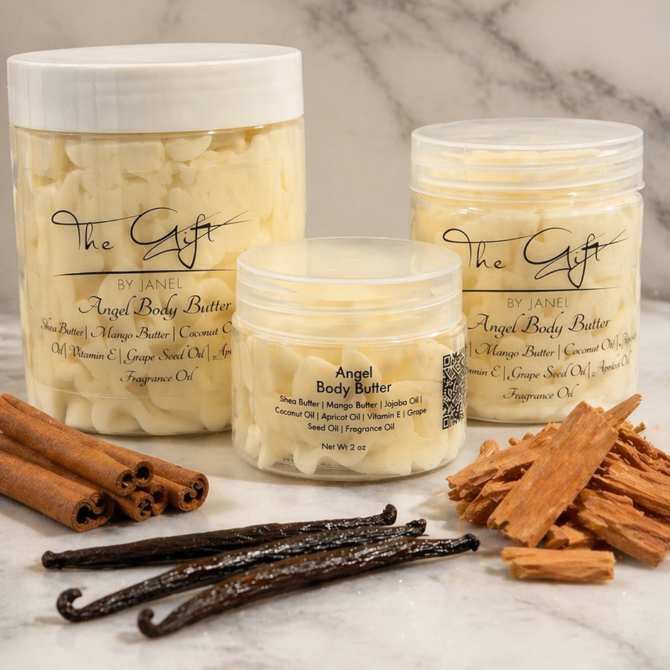 Three jars of 'Angel Body Butter' with cinnamon sticks, vanilla beans, and a cinnamon roll on a marble surface.