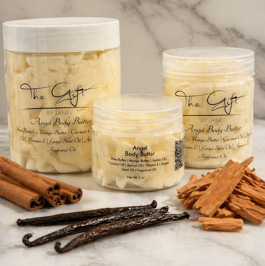 Three jars of 'Angel Body Butter' with cinnamon sticks, vanilla beans, and a cinnamon roll on a marble surface.