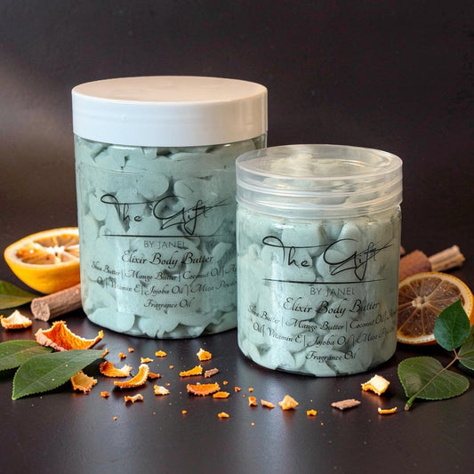 Two jars of 'The Gift' body scrub with orange peels and leaves on a dark background