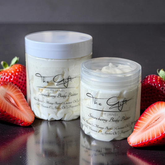 Two containers of strawberry body butter with strawberries on a dark surface