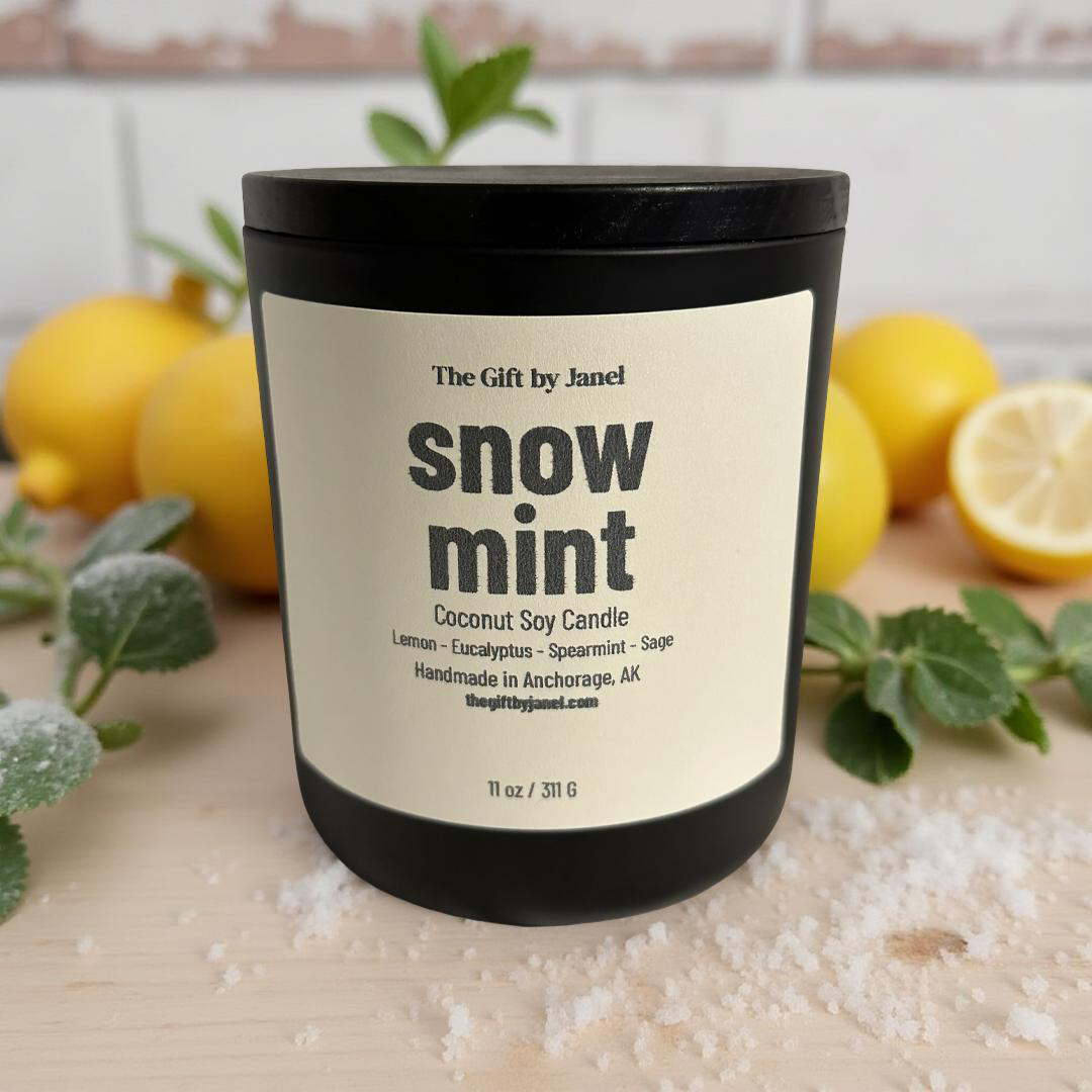 Coconut soy candle labeled 'snow mint' with lemons and greenery in the background