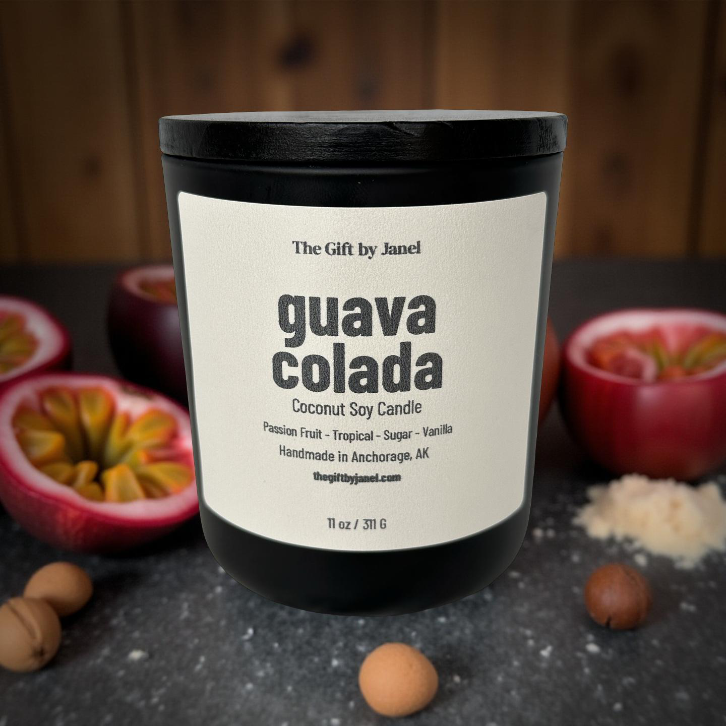 Candle labeled 'guava colada' with passion fruits and nuts on a dark surface