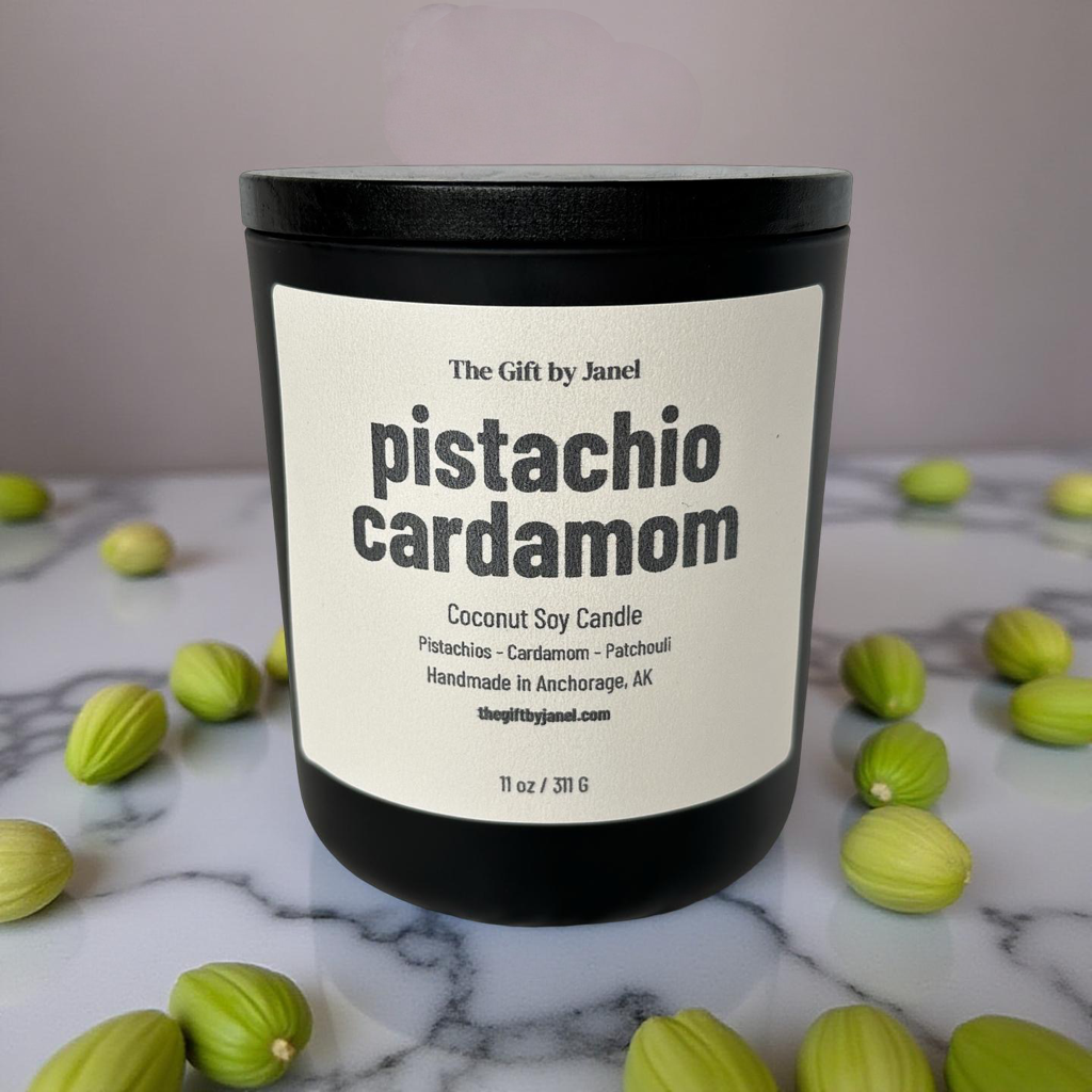 Pistachio cardamom candle with green pods on a marble surface