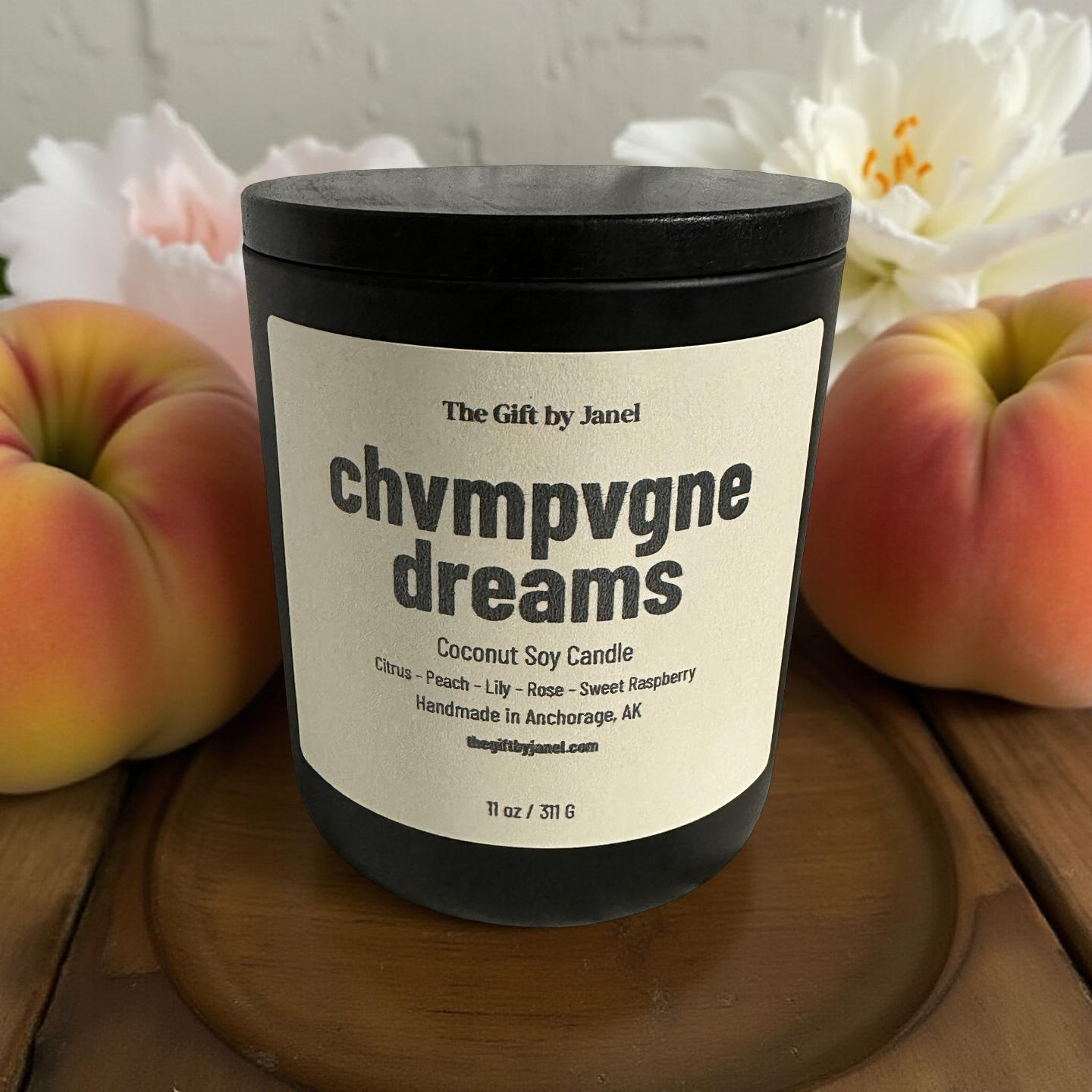 Candle labeled 'chvmpvgne dreams' with peaches and flowers in the background
