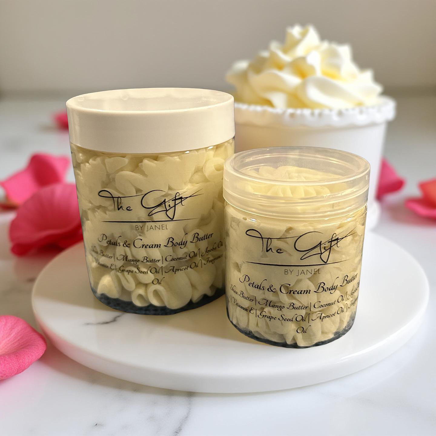 Two jars of 'Peach & Cream Body Butter' by Jane on a marble surface with pink flowers.
