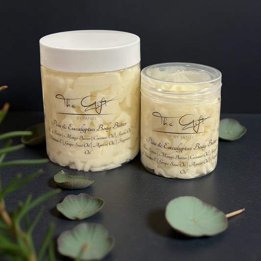 Two jars of body butter with decorative leaves on a dark surface