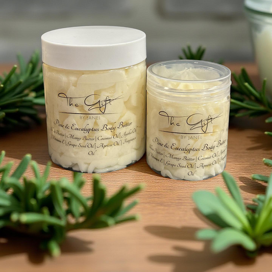Two jars of body butter on a wooden surface with greenery around