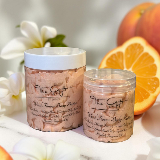 Two jars of body butter with flowers and oranges in the background
