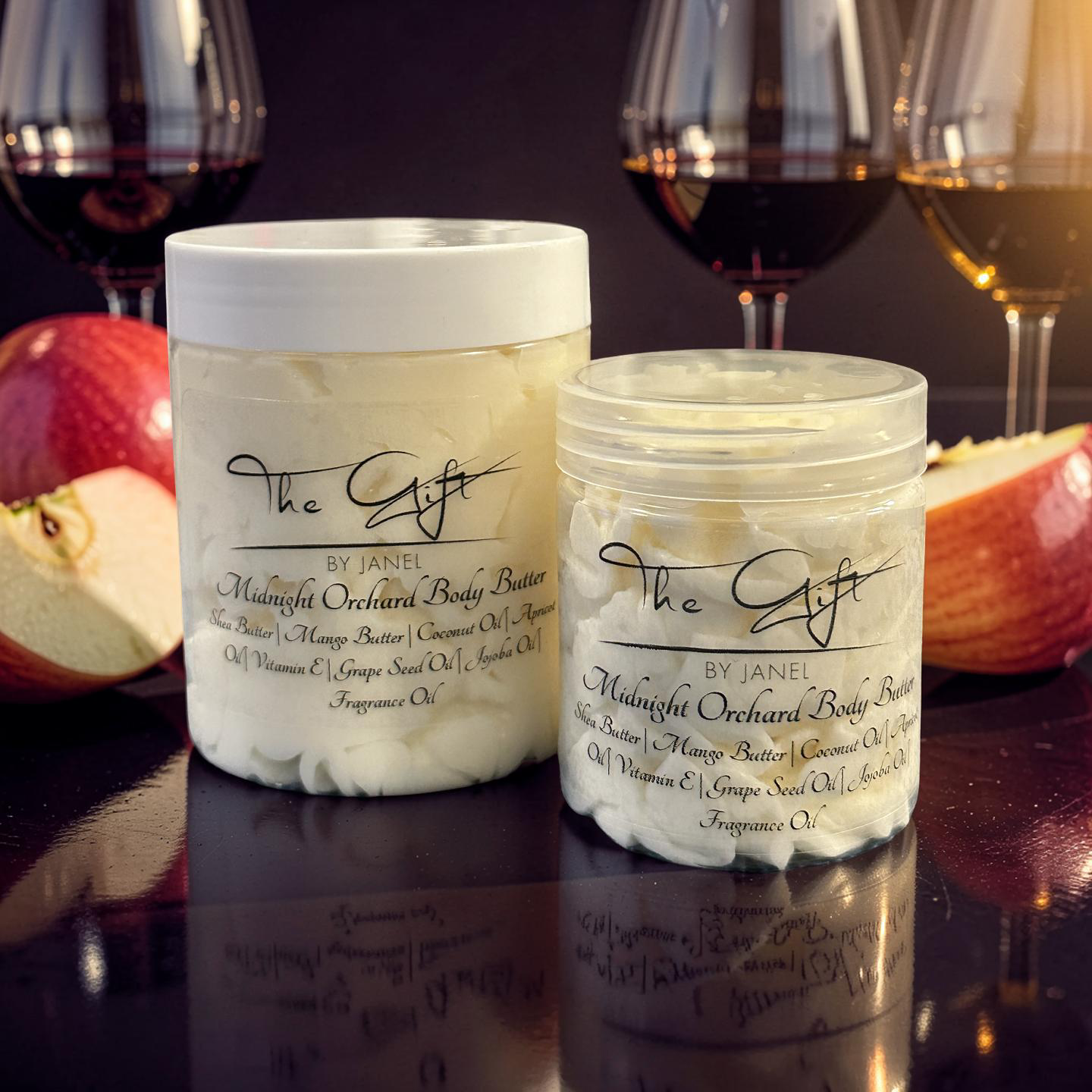 Two jars of 'The Gift' body butter with wine glasses and apples in the background.