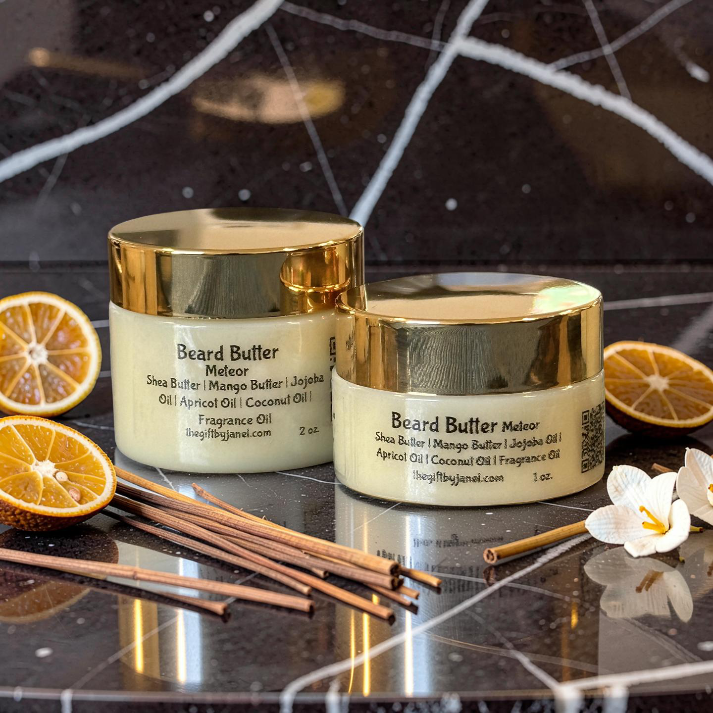 Two containers of Beard Butter Meteor with sliced oranges and flowers on a dark surface.