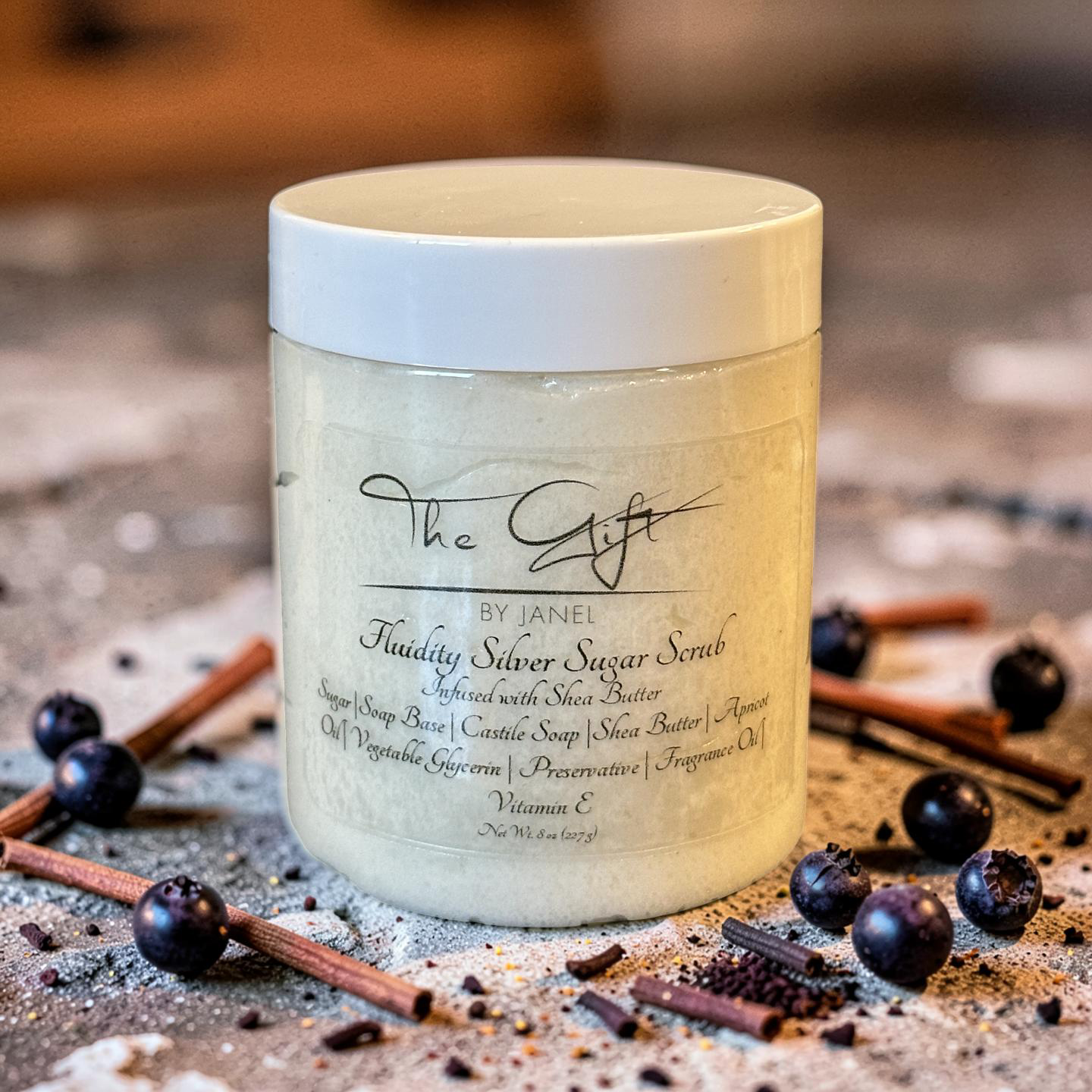 Jar of Fluidity Silver Sugar Scrub with ingredients on a rustic background