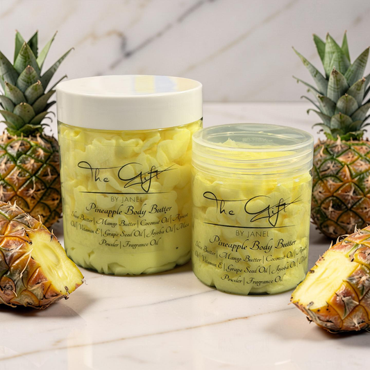 Two jars of pineapple body butter with pineapples on a marble surface