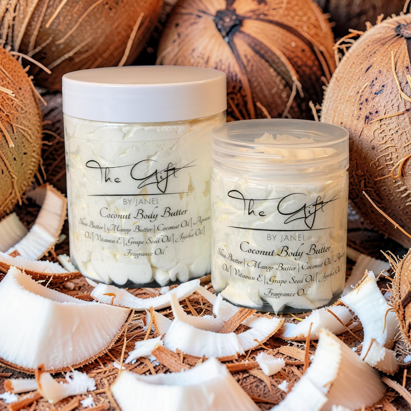 Two containers of coconut body butter surrounded by coconuts and coconut shavings.
