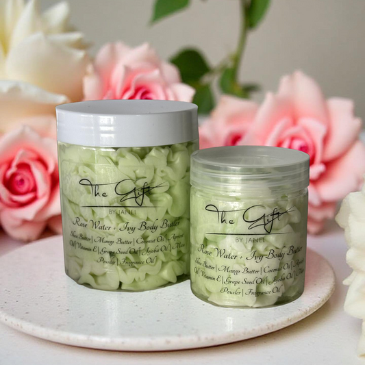 Two jars of body butter on a white plate with pink flowers in the background