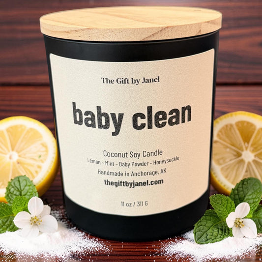 Coconut soy candle labeled 'baby clean' with lemons and mint leaves on a wooden background